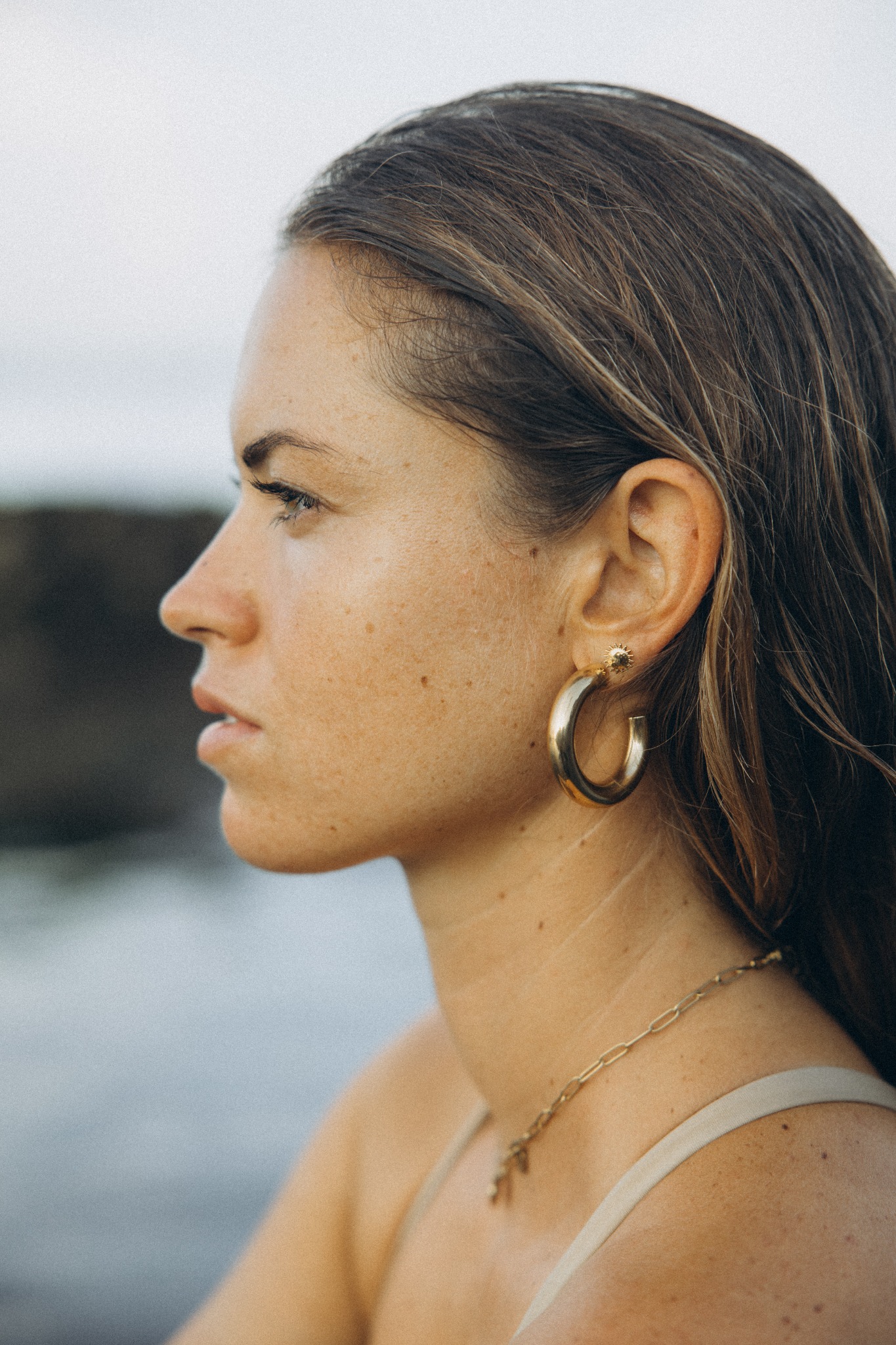 Ruhiges Profilportrait mit goldenem Schmuck